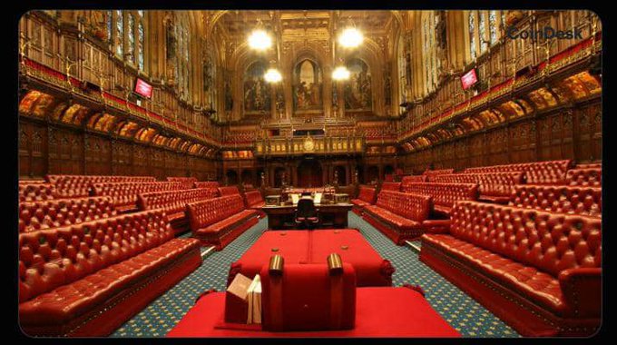 The ornate interior of the UK House of Lords chamber, featuring rows of distinctive red leather benches and gilded Gothic architecture, is shown with a watermark reading "CoinDesk." The image visually anchors the post's news about the House of Lords passing an amendment requiring the Treasury to develop a national digital asset strategy covering crypto, stablecoins, and tokenized securities.