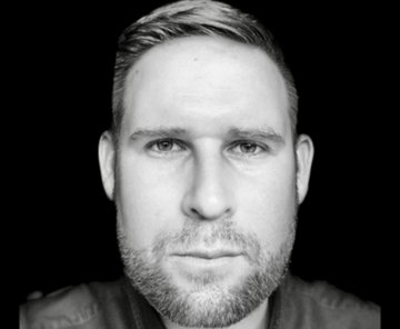 A black-and-white close-up portrait shows a man with light hair and stubble looking directly at the camera against a dark background. The image likely depicts someone the poster views negatively, contrasted with the named figures (Knut Svanholm, Jeff Booth, George Bodine, and Nick Szabo) whom they consider trustworthy, highlighting a sense of betrayal or misaligned loyalties.