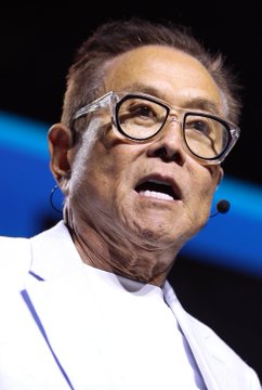 A close-up image of Robert Kiyosaki speaking at an event, wearing glasses and a headset microphone, accompanies his bold prediction that Ethereum ($ETH) could reach $95,000 by mid-2027—a roughly 60X increase from current levels.