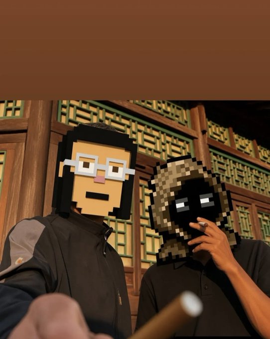 Two people posing for a photo with pixelated digital masks over their faces—one wearing glasses, the other in a hood—standing in front of an ornate wooden and green patterned wall.