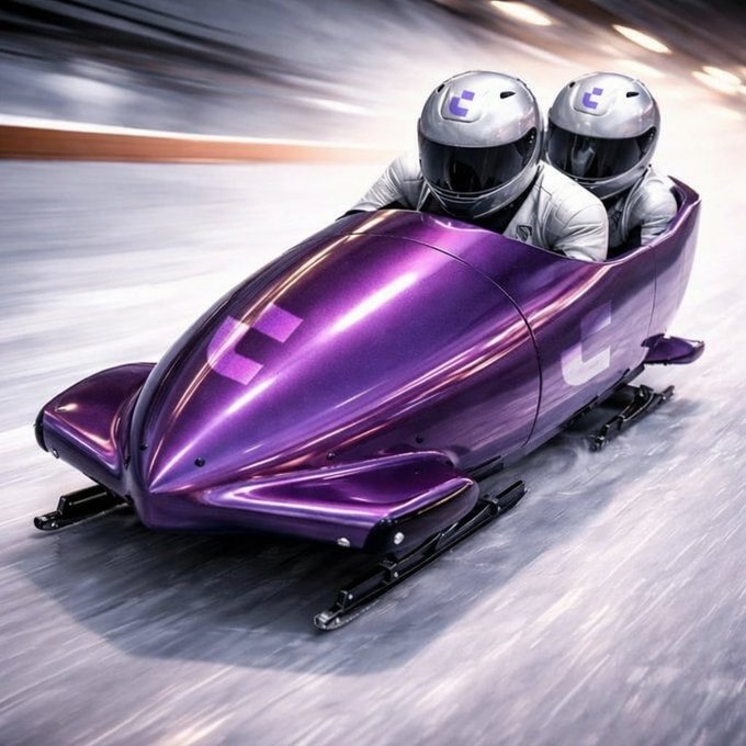 Two helmeted riders speed down an ice track in a sleek purple bobsled featuring a 'U' logo, suggesting a branded sledding experience.