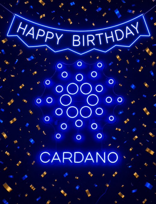 A digital graphic with a blue neon aesthetic displays 'HAPPY BIRTHDAY' in a banner above the Cardano logo and the word 'CARDANO', set against a dark background with gold and blue confetti.