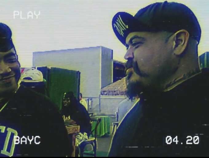 The image shows a man wearing a cap at an outdoor event, styled as a VHS camcorder recording with a "PLAY" indicator, "BAYC" text, and the timestamp "04.20" displayed on the screen. The BAYC label and "04.20" timestamp reference the Bored Ape Yacht Club NFT collection, aligning with the post's celebration of BAYC community membership.