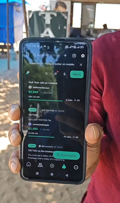 The image shows a man holding a black cell phone with a green screen, displaying some sort of mobile application or information related to cryptocurrency. The text visible in the photo suggests that he might be talking about pump fun and is possibly showing off a profile or transaction on his app. The focus on this specific information makes it clear how the content of the image connects to the post.