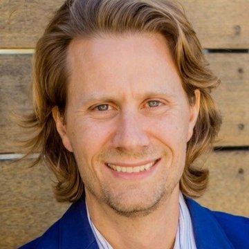 A headshot of a smiling man with long blond hair wearing a blue blazer, likely depicting Cory Klippsten, the Swan Bitcoin CEO referenced in the accompanying post about Jack Mallers' role at Twenty One Capital.