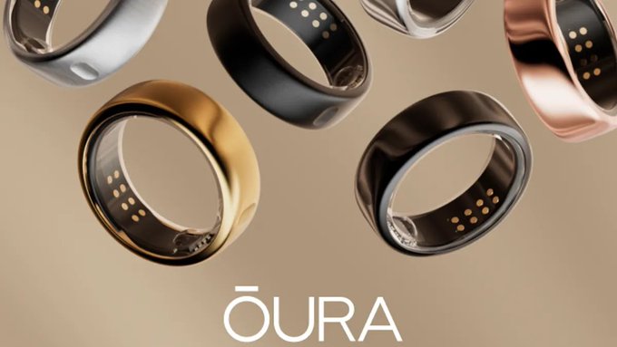 Product advertisement showing multiple OURA smart rings in various colors (silver, black, gold, rose gold) with the OURA brand name displayed at the bottom.