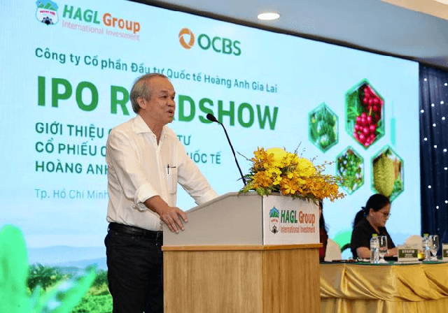 A man speaks at a podium during the HAGL Group IPO Roadshow in Ho Chi Minh City, with branding for HAGLGroup International Investment and OCBS visible on the screen behind him.