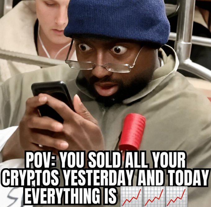A man in a blue bucket hat and glasses stares in shock at his phone, with the caption "POV: YOU SOLD ALL YOUR CRYPTOS YESTERDAY AND TODAY EVERYTHING IS 📈📈📈" overlaid above rising red chart lines, humorously capturing the regret of selling crypto right before a price surge.
