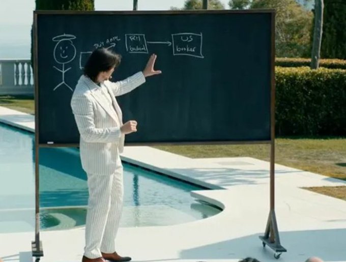 A man in a white striped suit stands by a pool, gesturing toward a chalkboard that displays a diagram connecting "Robinhood," "Kill Order," and "US broker" with an arrow, illustrating the trading controversy. The image visually represents the meme about Robinhood's role in halting retail trades during the meme stock frenzy.