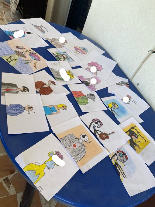 Colorful hand-drawn illustrations of various characters are spread across a blue table, with white circles covering some faces.