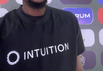 A person with a beard wearing a black t-shirt with the 'INTUITION' logo, with a Foresight Forum step-and-repeat banner visible in the background.