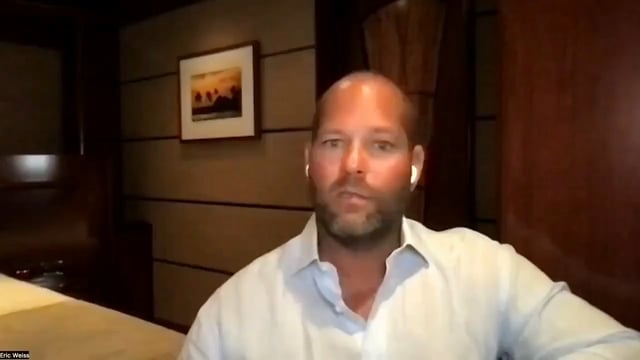 A man identified as "Eric Weiss" appears on a video call in a dimly lit room with wood-paneled walls and a framed picture, seemingly leading a discussion that aligns with the post's message advocating for dollar-cost averaging and holding Bitcoin.