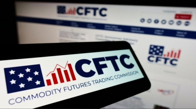 A close-up view of a smartphone screen displaying the 'CFTC' (Commodity Futures Trading Commission) logo, with the official CFTC website blurred in the background.
