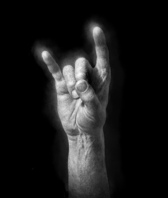 The image features a close up of an upside down hand with fingers spread wide apart, making a "V" shape as if it were a horn. The background is black, which contrasts with the white color of the hand and makes the hand stand out even more. The image also contains text that reads "@Minotaur_Man minting @TransientLabs". This suggests that the image might be related to an artist or creator who has minted this piece of art.