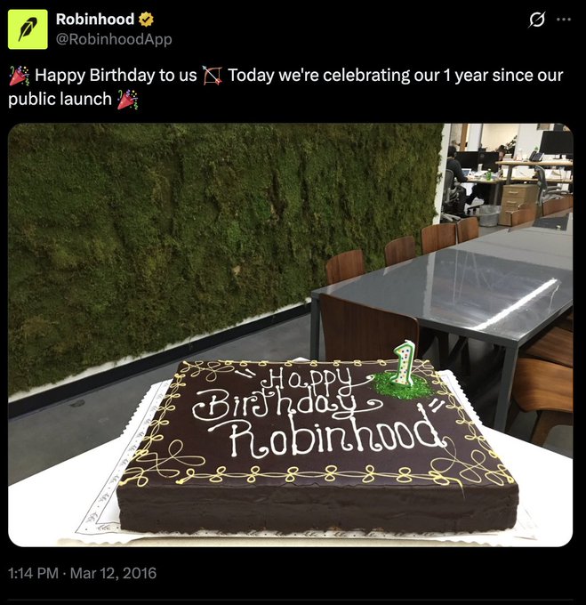 A screenshot of a 2016 Robinhood (@RobinhoodApp) tweet celebrating their 1-year anniversary since public launch, featuring a photo of a chocolate sheet cake with "Happy Birthday Robinhood" written in white icing and a green "1" candle in an office setting. The accompanying post promotes a meme coin (CA: 0x67898c02eaababe8fb87095c62cdea6223adcbb9) with 313 participants, using the anniversary celebration imagery as a callback to draw a parallel between the project and a legitimate financial platform.
