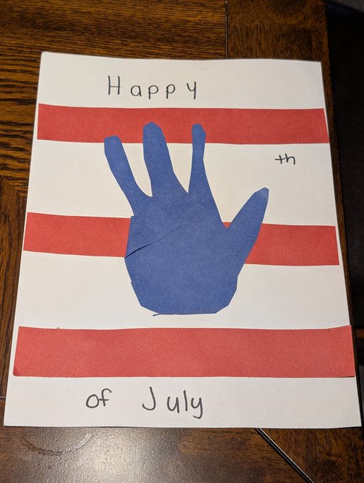 A child's handmade Fourth of July craft on white paper featuring a blue handprint in the center with red paper stripes across the background and handwritten text reading 'Happy 4th of July'.