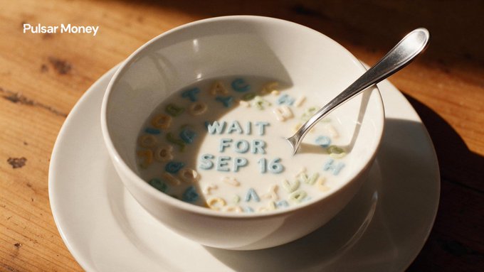 Close-up photo of a white bowl of cereal with alphabet-shaped pieces in milk, with letter pieces arranged to spell 'WAIT FOR SEP 16', branded 'Pulsar Money' in the corner.