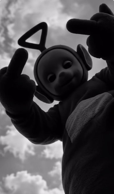 A Teletubbies character (Tinky Winky) looms large against a cloudy sky, peering down with both hands raised and pointing fingers. The unsettling, oversized perspective pairs well with the cryptic "GM Degens Mood today:" post—capturing that eerie, ambiguous vibe traders often feel at the start of a session.