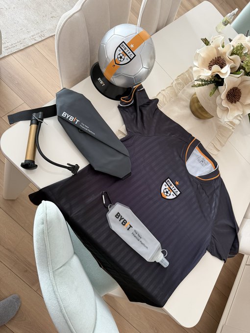 The image displays Bybit branded merchandise, including a soccer ball, a jersey, and a foldable water bottle, mirroring the items mentioned in the post. The Bybit logo and "BYB T.F.C." are clearly visible on the soccer ball and jersey.