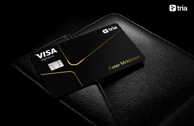 The image features a black wallet with a Visa card sitting on top of it. The wallet has a sleek design and appears to be made from genuine leather material. The Visa logo is prominently displayed on the front of the wallet, indicating that it's a credit card holder. The wallet is placed in a dark setting, which contrasts nicely with its black color and adds depth to the image.