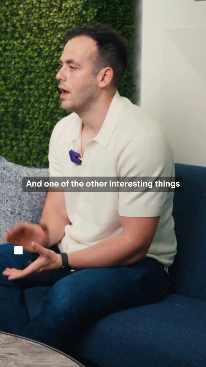 The image shows a man sitting on a couch, wearing a white shirt and blue jeans. The text "And one of the other interesting things" can be seen below him, which might be related to the content of the post about DeFi upgrades or stablecoins.