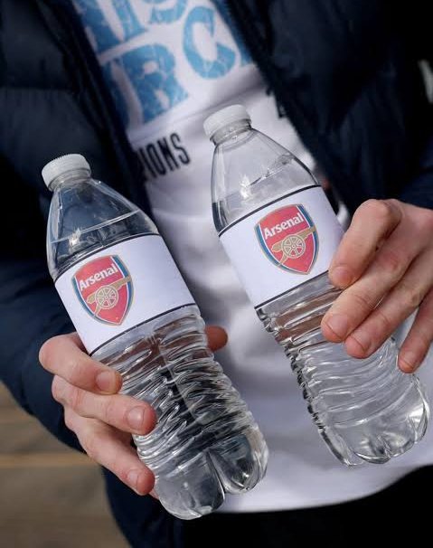The image shows a person holding two water bottles, each containing 500ml of water. The person is wearing a black jacket and has their hands around the bottles. In the background, there are some text elements that read "@River4Fun" and "@River4fun". This suggests that the person might be promoting or discussing something related to the river or water in general.