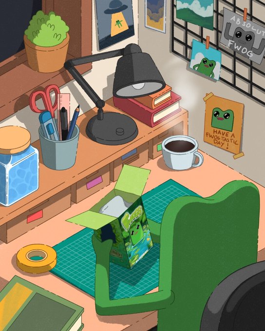 A cozy desk scene with a frog-themed green blindbox being unboxed, surrounded by art supplies, a lamp, and wall art reading "ABSOLUT FWOG" and "HAVE A FWOGTASTIC DAY." The image captures the excitement of receiving the fwog blindbox, matching the post about the collaboration with @phygitals and the delivery of these collectibles.