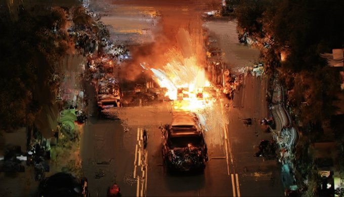 An aerial night view shows a vehicle engulfed in flames on a residential street, with firefighters and spectators gathered around the scene.