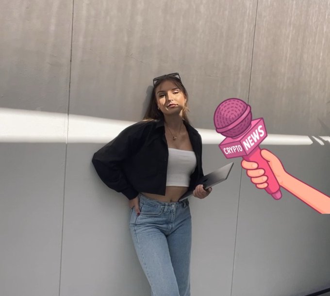 A woman in a black jacket, white tube top, and jeans leaning against a wall, with a cartoon 'Crypto News' microphone edited into the image.