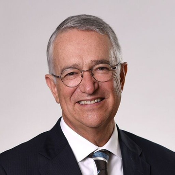 An older man with gray hair and round glasses smiles warmly while wearing a dark suit and striped tie, appearing to be the Mexican billionaire Ricardo Salinas Pliego referenced in the accompanying post about Bitcoin advocacy.