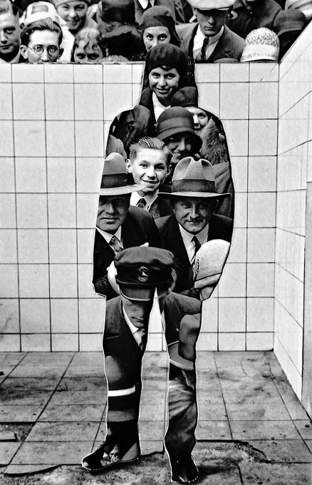 A black and white surrealist photograph showing a woman and young boy standing against a tiled wall, with a crowd of onlookers visible above and distorted, elongated reflections of the figures appearing below.