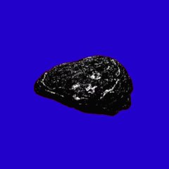 A black meteorite or space rock floats against a solid blue background, with bright reflective flecks visible on its surface.