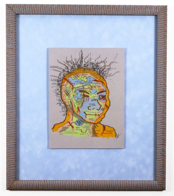 A framed mixed-media artwork depicting a portrait of a person composed from map fragments, with yellow and green tones and sketch-like spiky hair, displayed in a textured tan frame against a light blue background.