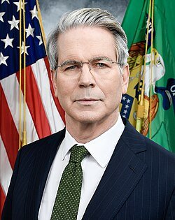 The image shows an official portrait of a gray-haired man in a dark suit and green tie, standing in front of an American flag and what appears to be a Treasury Department flag. The post appears to misidentify the man as Scott Bessent, but the image actually depicts Secretary of the Treasury Scott Bessent — wait, it does appear to be Treasury Secretary Scott Bessent in an official portrait, which connects to the post's claim about the Clarity Act being "at the 1-yard line" and its significance for crypto legislation.
