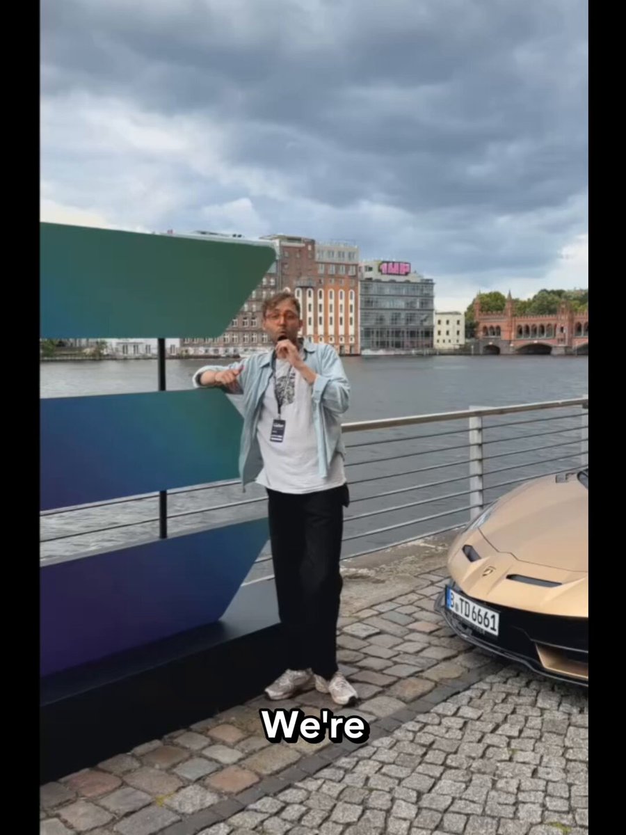 The image shows a man standing next to a car, with a sign that says "We're" above him. The background features a river and buildings, suggesting an urban setting. The caption of the image reads "What's the biggest lie in Web3? We got to ask people at Solana Summit some questions".