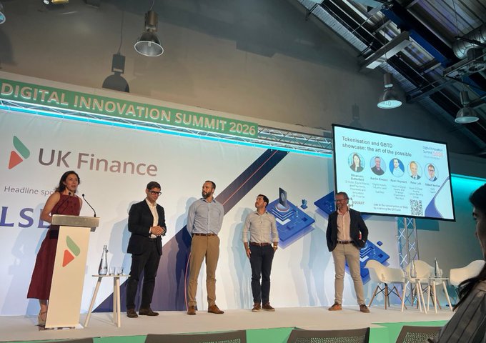 A panel discussion at the 'Digital Innovation Summit 2026' hosted by UK Finance, featuring five speakers on stage with a presentation slide titled 'Tokenisation and IBRTD showcase: the art of the possible'.