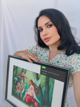 A woman with dark hair in a floral blouse holds a framed digital display showing a fantasy illustration of a fairy in a forest, with a small label reading 'Screenshot.'