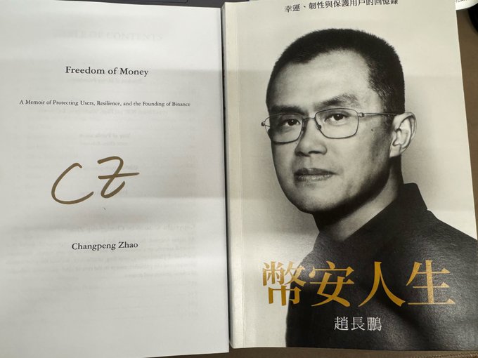 A signed copy of *Freedom of Money* (Binance Life) by Changpeng Zhao (CZ), featuring his portrait and "CZ" signature on the title page alongside Chinese text reading "幣安人生" and "趙長鵬." The image relates to the post by showing the book the author re-reads for energy during community building, with CZ's signature symbolizing the personal inspiration drawn from his memoir.
