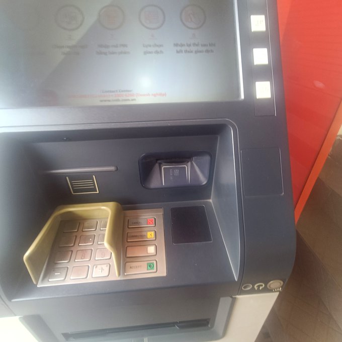 A close-up view of an ATM machine interface with a keypad, card slot, and a screen displaying instructions including 'Choose a withdrawal amount', 'Withdraw 200K', and a credit union website 'www.credit.com.sg'.