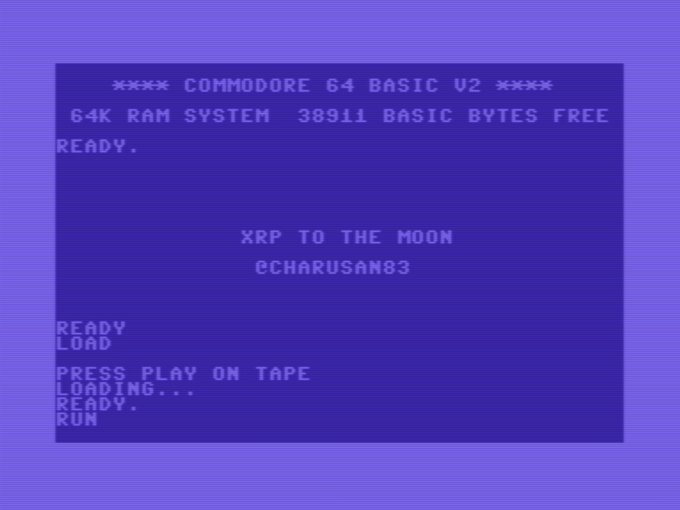 The image features a purple screen with white text, which appears to be an old computer game or program. It seems that the main focus of the image is the word "XRP", as it is written in large white letters at the bottom right corner of the screen. The background color of the image is purple, and there are some other words on the screen such as "load" and "play".