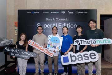 In the image, a group of six people are standing together holding up signs with various logos such as "base", "alibaba cloud", and "theta nuts". The group appears to be posing for a photo at an event or gathering related to AI technology. One person is wearing a blue shirt that says "base AI connect" on it, while another person has a sign that reads "superai version". There are also signs with the names of other companies and individuals in the background, indicating that this could be a special event or collaboration involving these organizations.