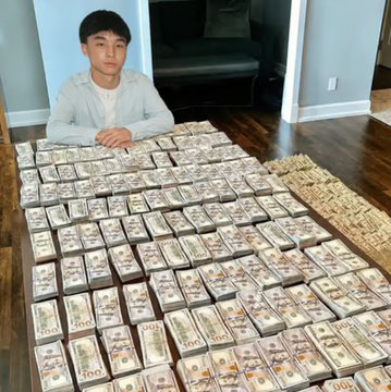 A young man poses behind a massive display of stacked US $100 bills arranged in neat rows, humorously illustrating the spectacular 500%+ surge of the $KIMCHI memecoin over the past 24 hours and its consolidation before retesting its all-time high.
