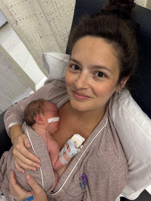 A mother holds her newborn baby, likely in a hospital setting, with a tubing and tape visible on the baby. The image complements the "LFG!" post by celebrating a new beginning and excitement.