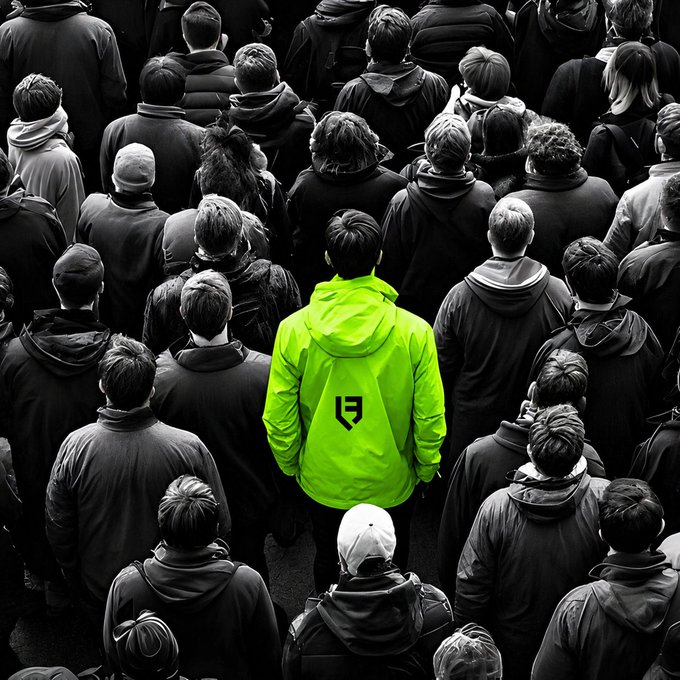A black and white photo of a crowd viewed from above, with one person in the center standing out by wearing a bright neon green jacket featuring a logo.
