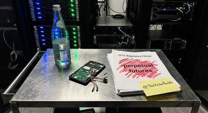 A server room scene showing a motherboard, water bottle, and printed "CFTC Regulatory Filings" document titled "perpetual futures" with a sticky note reading "@TheTictorBuilds".