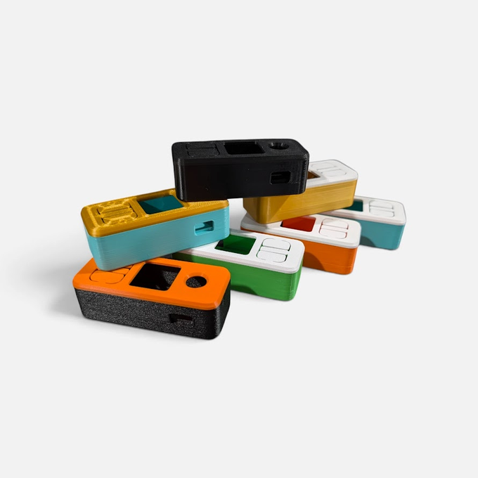 A stack of colorful Nintendo Labo VR Kit Joy-Con shells and housings in black, orange, yellow, teal, green, white, and red rests on a white background, showcasing vibrant color combinations that match the post's "Color combos getting lit" caption.