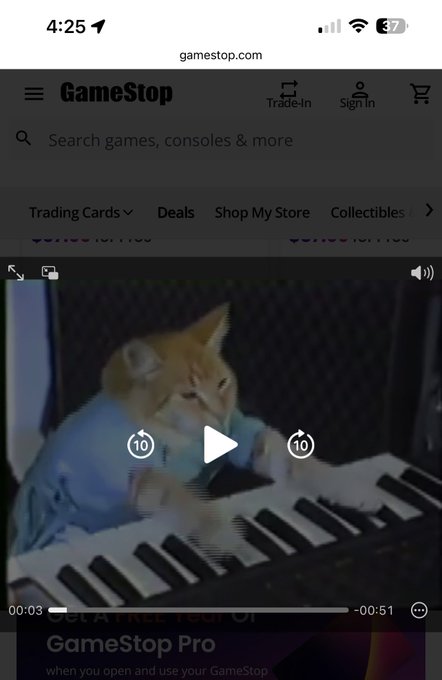 A mobile browser screenshot of gamestop.com displaying a video of a small dog wearing a blue shirt playing a keyboard.