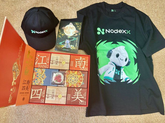 A promotional merchandise layout featuring a black Nodexx baseball cap, a black t-shirt with a white hooded character graphic and green 'Nodexx' logo, and an open orange box of '江南四美' (Jiangnan Four Beauties) mooncakes in Jiang, Nan, Si, and Mei flavors.
