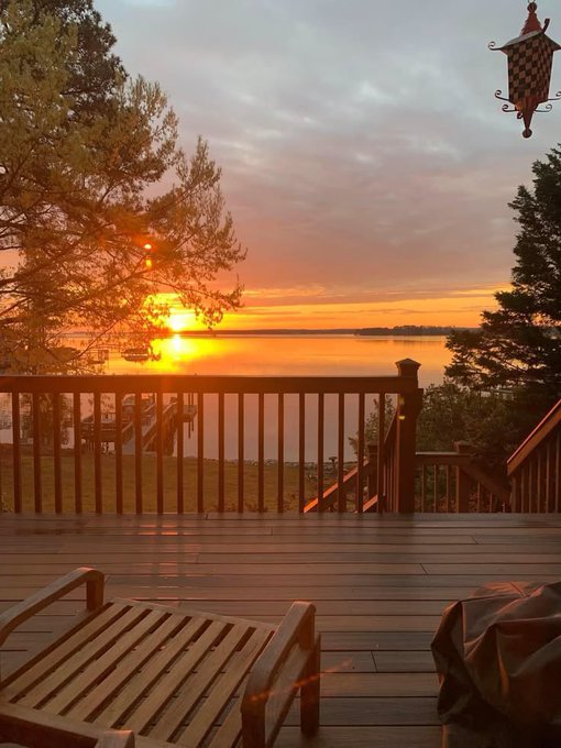 A serene lakeside deck at sunset, with warm golden light reflecting off the water and a wooden railing in the foreground—paired with a text post highlighting how projects like @sleepagotchi and @TheARCTERMINAL are making Web3 more accessible through wellness-driven engagement and verifiable AI.