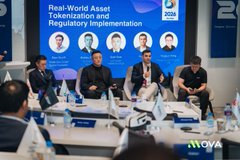 A panel discussion at a conference with the banner 'Real-World Asset Tokenization and Regulatory Implementation', featuring five seated speakers at a MOVA-branded table.